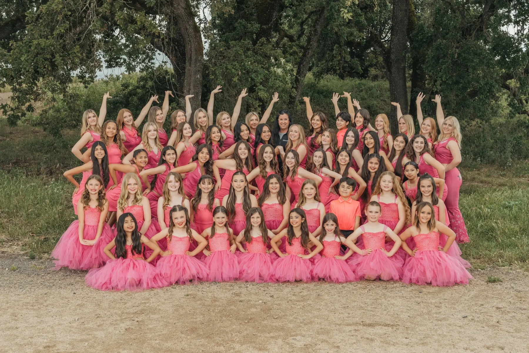 Academy of Danse Competition Company dancers posing together outdoors in pink costumes